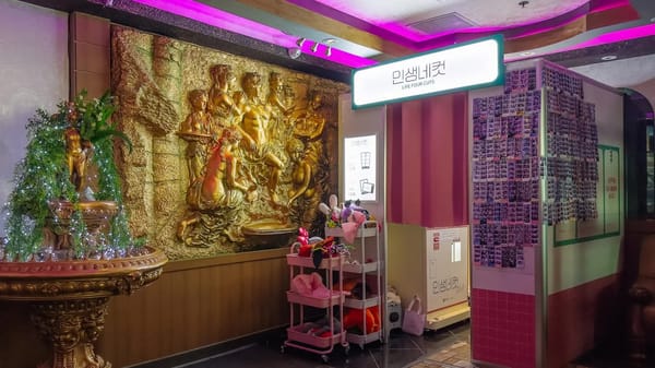 Pang Pang Karaoke lobby with purple neon and gold relief on Rue Mackay